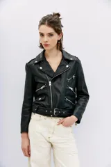 Campera estilo biker confeccionada en cuero ovino, con solapas amplias, charreteras en los hombros y cinturón ajustable en la cintura. Presenta cierres metálicos en el frente y bolsillos laterales, con forro interior de poliéster.