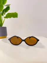 Lentes de sol con marco de acetato negro y lentes color ámbar.