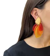 Par de aros colgantes con clip, hechos de resina combinada en una gama de colores que incluye amarillo, naranja y rojo. Diseño moderno y atemporal con movimiento.
