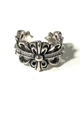 Anillo de diseño abierto con motivos florales y ornamentales en relieve, con acabado metálico envejecido.