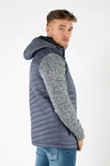 Campera híbrida con cuerpo acolchado en color gris azulado y mangas de felpa gris jaspeado. Cuenta con capucha, cierre frontal y bolsillos con cierres impermeables.