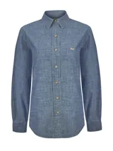 Blusa de manga larga Moroco de RKF, confeccionada en algodón denim chambray color azul, con cuello camisero, cierre frontal de botones de madera y detalle de bordado de pato en el pecho.
