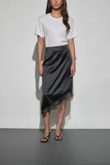 Pollera midi de satén color negro, con corte asimétrico y detalle de encaje en el ruedo.