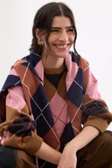 Sweater holgado con diseño de rombos en tonos marrón, negro y rosado, con detalles de lurex en las líneas divisorias. Presenta cuello redondo, mangas largas con puños acanalados y un corte relajado.