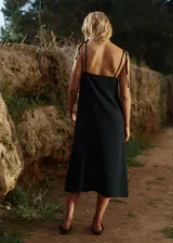 Vestido midi de lino y rayón, color negro, con escote recto, tirantes finos ajustables y tajo lateral.