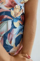 Malla enteriza de lycra premium, con diseño cruzado en el frente, escote en V y estampado floral en tonos azules, celestes y rosados.