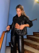 Campera corta de cuero sintético negro con textura croco, cierre frontal y cuello clásico.