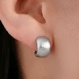 Aros tipo argolla pequeña de diseño ancho y superficie texturizada con acabado mate en tono dorado.