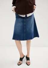 Falda midi evasé de denim azul con diseño de corte trapecio, tiro medio, trabillas y bolsillos.