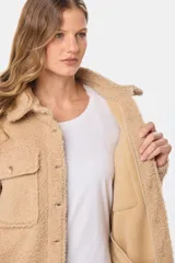 Campera tipo camisa confeccionada en tejido de sherpa, con cuello clásico, cierre frontal de botones y bolsillos delanteros con solapa.