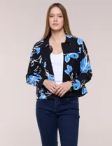 Campera liviana de poliéster color negro con estampado floral en tonos azules y blancos, cuello camisero, cierre frontal con botones y bolsillos en el pecho con solapa.