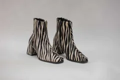 Botas cortas con estampado de cebra en blanco y negro, con cierre lateral y tacón cuadrado.