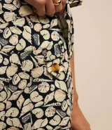 Short de tiro alto confeccionado en viscolino con estampa de caracoles, bolsillos delanteros con botones y detalle de pespunte.