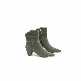 Bota de gamuza verde militar con punta fina, taco ancho y caña corta. Presenta costuras decorativas blancas en forma de cruz en el lateral y una línea horizontal alrededor de la caña. Cuenta con cierre lateral interno.