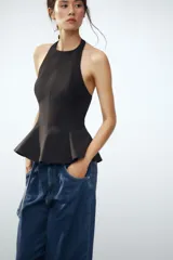 Top rosa claro, entallado, con cuello halter que se abrocha en la nuca y espalda descubierta. El bajo tiene un corte peplum acampanado.