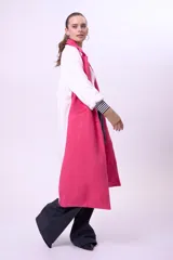 Tapado largo sin mangas de color fucsia, con solapas amplias y diseño abierto. Presenta una estructura fluida y moderna, ideal para superponer sobre otras prendas.