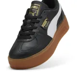 Championes Puma Palermo Elevata de cuero negro con franja lateral blanca, detalles dorados y suela marrón de plataforma.