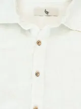 Camisa de manga larga confeccionada 100% en lino, color verde claro, con calce recto y relajado. Presenta frente abotonado con botones de coco con logo y el patch característico de Polonio.