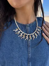 Collar corto con diseño de corales de resina en tonos beige y blanco, intercalados con cuentas cilíndricas. Cuenta con cadena de extensión de acero quirúrgico para regular el largo.