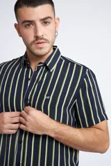 Camisa de manga corta con diseño a rayas verticales en color azul marino y blanco. Presenta cuello clásico, cartera abotonada frontal y logo bordado en el pecho. Posee un corte slim fit.
