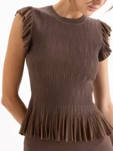 Top marrón de punto plisado con escote redondo, sin mangas y detalles de volados en sisas y en el ruedo con acabado peplum.