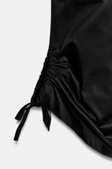 Pantalón culotte de tiro medio, color verde militar, con cintura elástica y bolsillos laterales ocultos. Presenta un diseño de bajo ancho con aberturas ajustables mediante cordones fruncidos en los laterales.