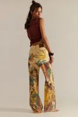 Pantalón de jean recto tiro medio color amarillo, con estampado artístico que incluye girasoles, peces y olas.