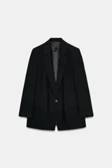 Blazer negro de manga larga con cuello solapa y cierre frontal de un solo botón. Presenta bolsillos delanteros con solapas.