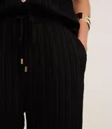 Pantalón femenino de corte recto y fluido, cintura alta con elástico y lazo ajustable. Tejido de chiffon texturizado.
