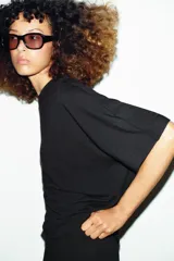 Remera oversize gris melange de tejido fluido, con cuello redondo y mangas cortas amplias.