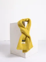 Bufanda de tejido de punto en color amarillo mostaza, confeccionada en lana, con etiqueta de marca visible.