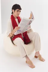 Sandalia color beige con tira ancha de cuero sobre el empeine, hebilla metálica plateada y taco geométrico de madera.