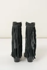 Botas de cuero color marrón con caña media, punta fina, taco de madera y detalle de flecos laterales.