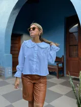 Bermuda de cuero sintético en color marrón, con diseño de corte recto, tiro medio y costuras verticales decorativas en el frente.