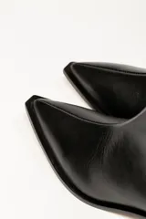 Bota corta de cuero metalizado en tono plateado con efecto arrugado, de caña media, punta fina y taco bajo cuadrado.