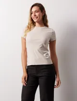 Remera de manga corta confeccionada en tejido modal con textura acanalada (rib). Presenta un diseño ajustado al cuerpo con cuello redondo a la base.
