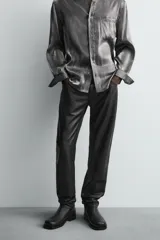 Pantalón slim fit confeccionado en piel, con diseño de cinco bolsillos, cierre frontal de cremallera y botón.