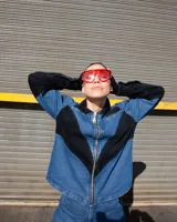 Camisa de denim azul y negro con cortes curvos y simétricos, cierre frontal de alpaca y cuello en cuero vacuno. Incluye bolsillos delanteros con bordado del logo Temblad.