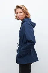 Campera impermeable azul marino con capucha desmontable, cierre frontal con botones a presión y cordón ajustable en la cintura.