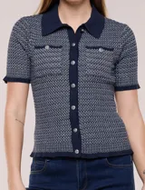 Cardigan de punto con textura Jacquard, cuello camisero, manga corta y cierre frontal con botones metálicos. Presenta bolsillos decorativos en el pecho.