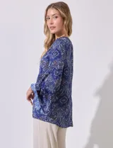 Blusa de satén estampado marca Grand & Greene, con cuello a la base fruncido, escote en V y lazo. Manga larga amplia con terminación acampanada.