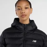 Campera puffer New Balance con capucha, cierre frontal bidireccional y puños elásticos. Diseño acolchado en color negro con logo de la marca estampado en el pecho.