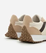 Championes estilo jogging con diseño de paneles en tonos gris, blanco y negro. Presentan cierre por cordones, suela de goma con relieve que se extiende hacia el talón y acabado en poliuretano.