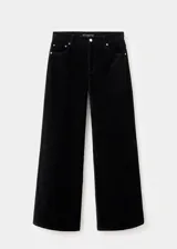 Jeans wide leg de terciopelo color negro, tiro medio, con cierre de botón y cremallera, trabillas y diseño de cinco bolsillos.