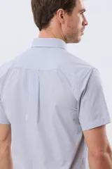 Camisa de manga corta con microcuadros en tonos celestes y blancos, calce slim, cuello con botones y bolsillo frontal con logo bordado.
