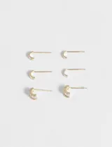 Set de tres pares de aros dorados con forma de media luna. Dos pares son lisos y el tercero tiene strass incrustado.