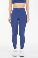 Calza deportiva larga de tiro alto, color azul, con bolsillos laterales funcionales y diseño anatómico de ajuste compresivo.