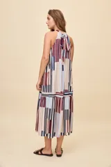 Vestido largo de silueta amplia y caída fluida, con escote halter fruncido y falda con recorte. Presenta diseño geométrico multicolor a rayas en tonos bordó, azul, celeste y beige.