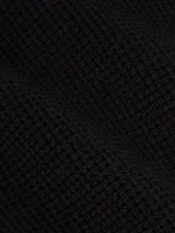 Sweater de punto negro con cuello alto y cierre frontal de cremallera. Presenta un pequeño parche con el logo 'ck' en la manga izquierda.