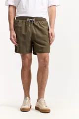 Short de baño azul, de corte clásico y largo corto, con cintura elástica y cordón ajustable bicolor. Cuenta con bolsillos laterales y uno trasero.